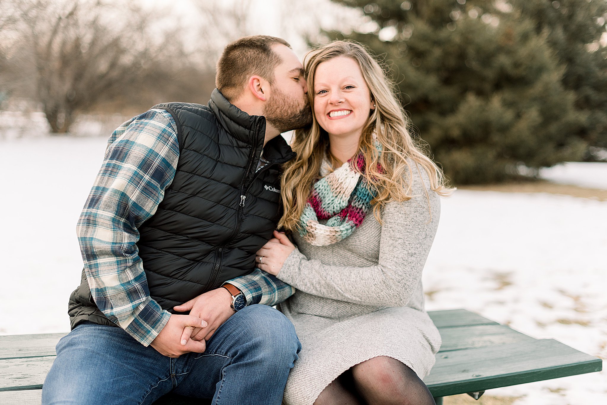 couple sitting during engagement session sioux falls south dakota engagement session in sertoma park