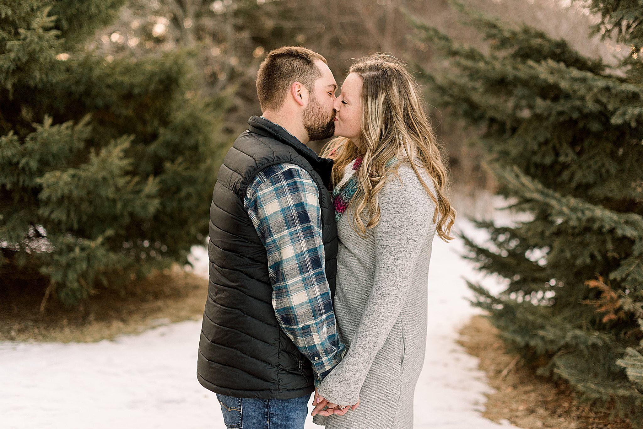 couple kissing during engagement session sioux falls south dakota engagement session in sertoma park