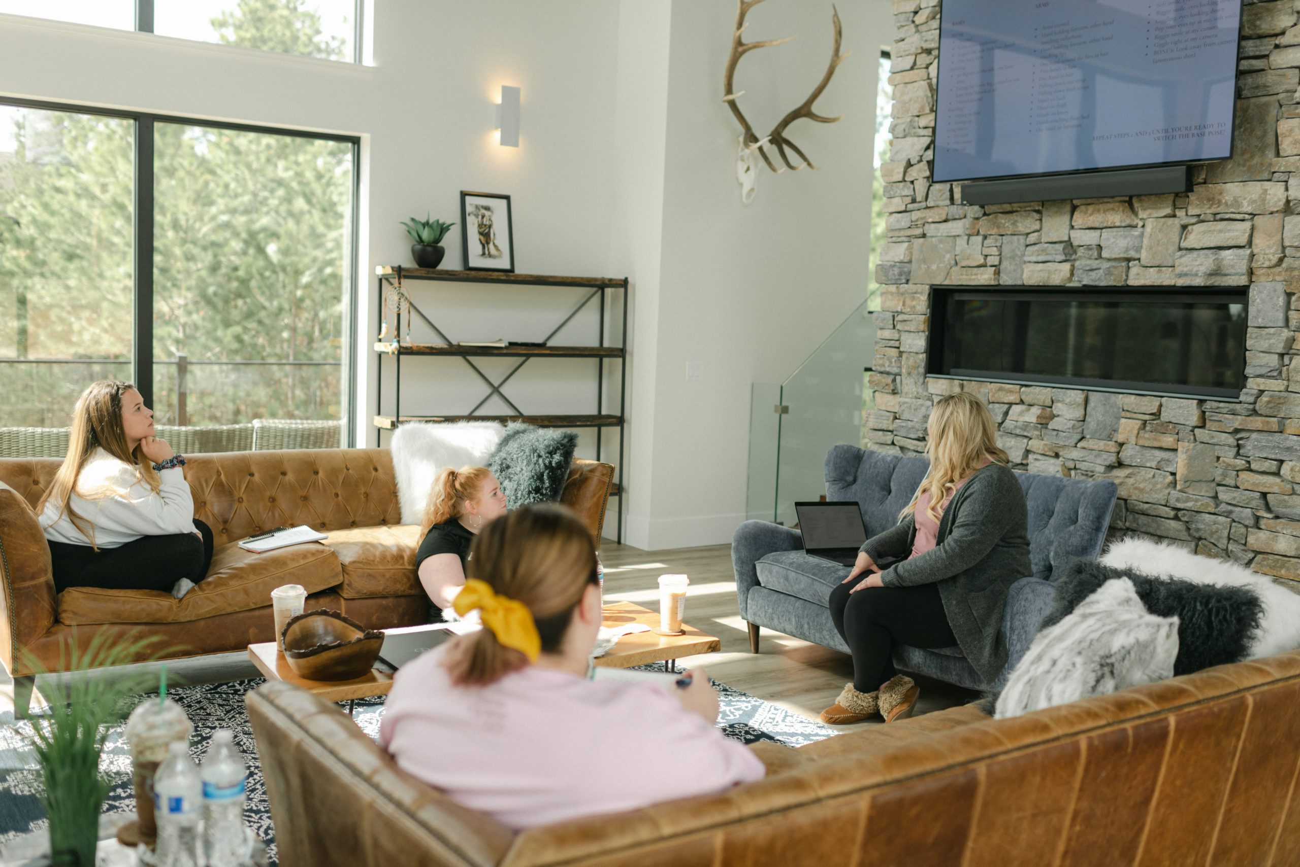 women sitting on couch in open room while business coach is speaking