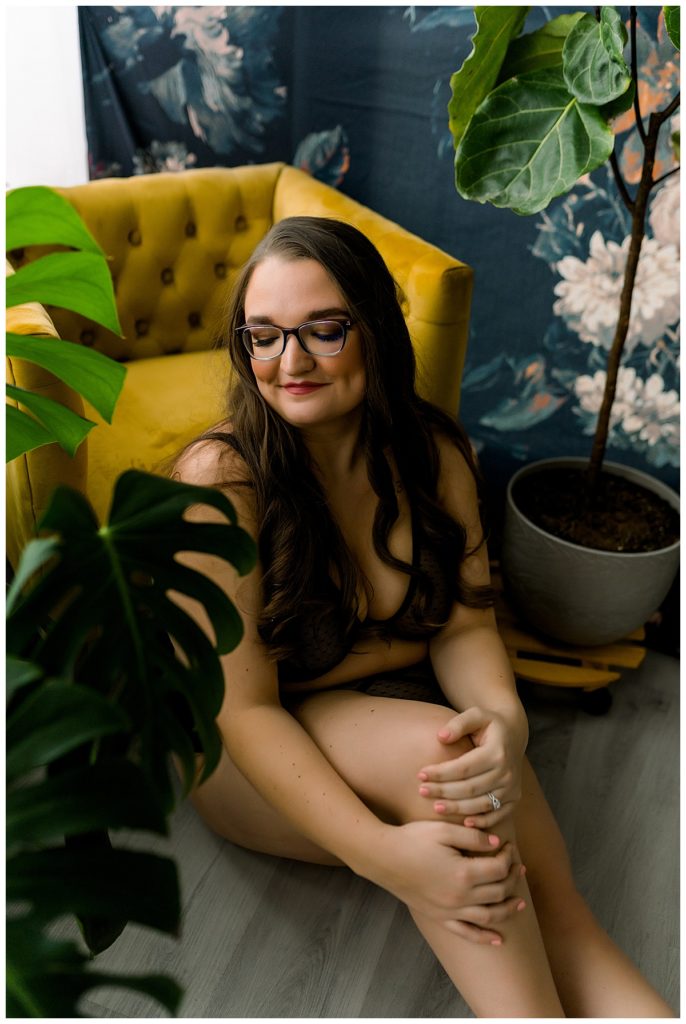 Woman looking down at shoulder during empowering boudoir session