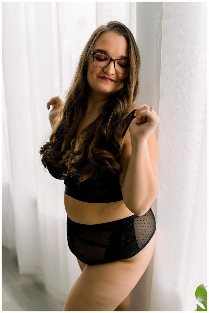 Lady holding lingerie outfit straps by Emma Christine Photography