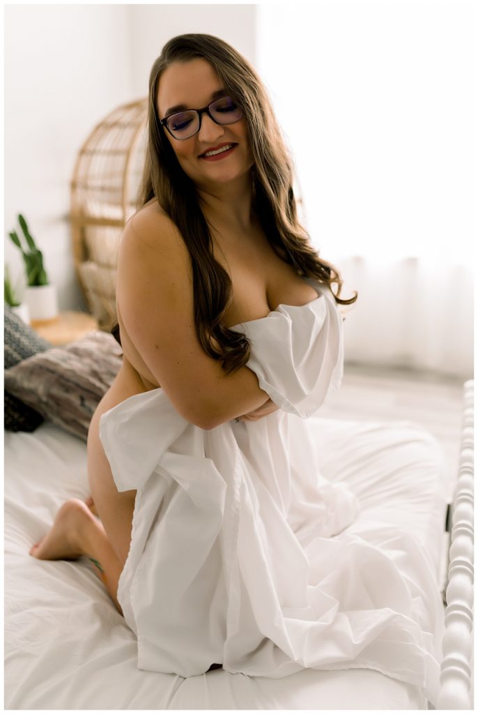 White linen sheet covering woman by Sioux Falls boudoir photographer