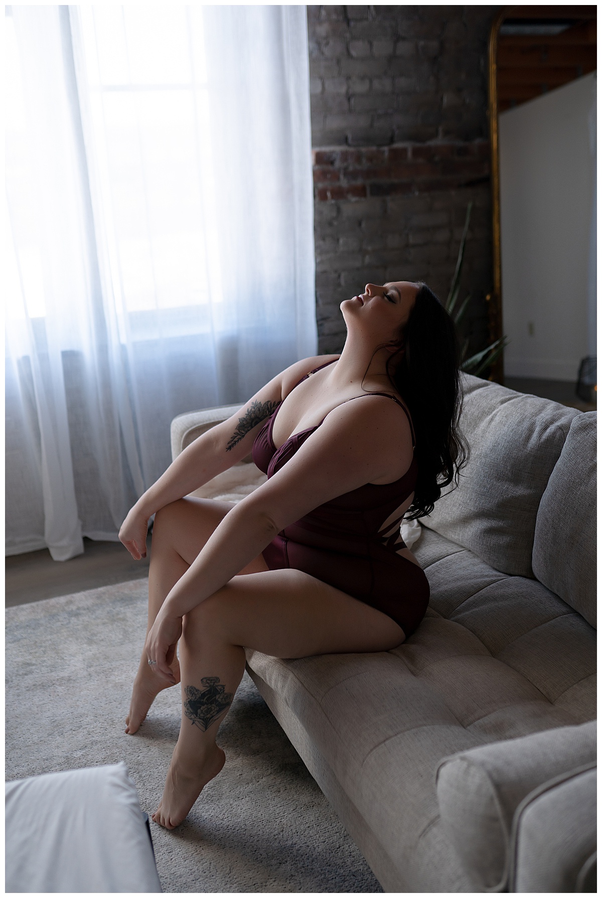 Girl sits on edge of couch for Sioux Falls Boudoir Photographer