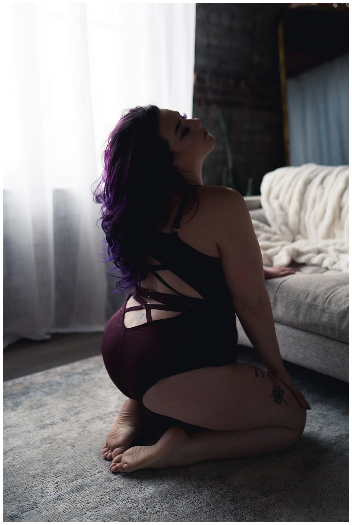 Lady Sioux kneels in front of bed for Falls Boudoir Photographer