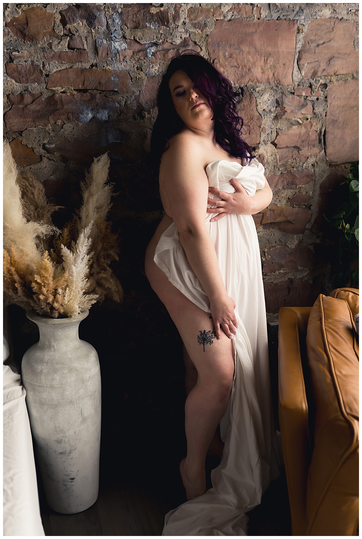 Woman covers body with sheet for Sioux Falls Boudoir Photographer