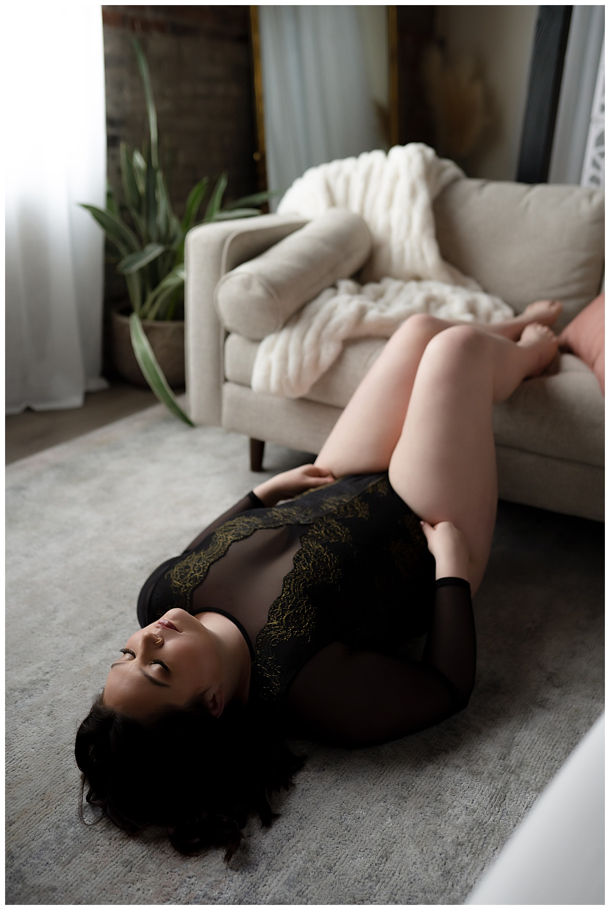 Girl lays on back with feet on couch in lingerie for  Sioux Falls Boudoir Photographer