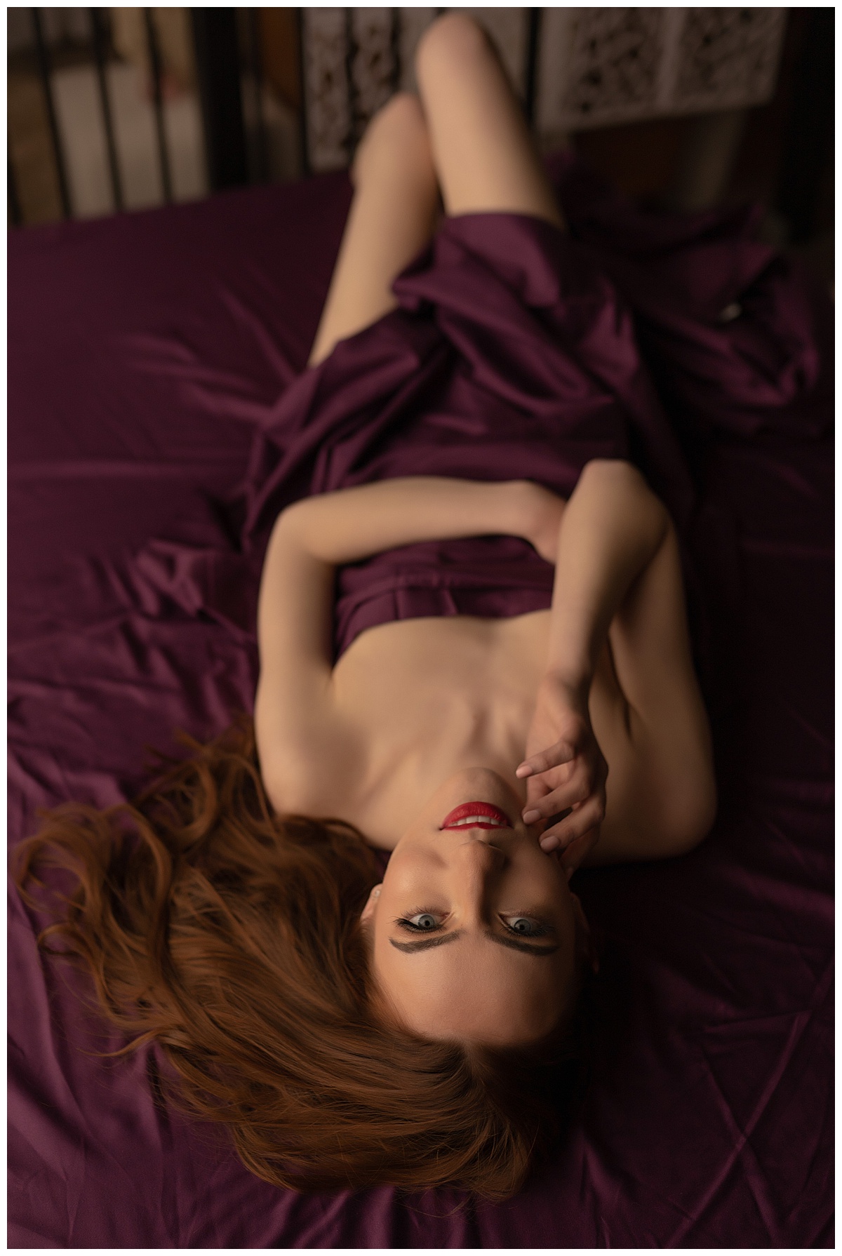 Female covers body with maroon sheet for Emma Christine Photography