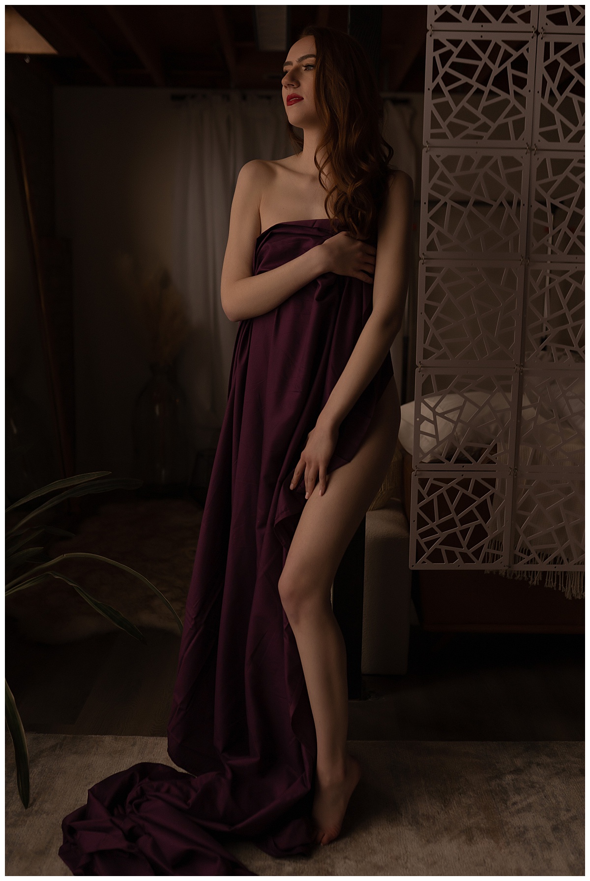 Adult covers body with maroon sheet for Emma Christine Photography
