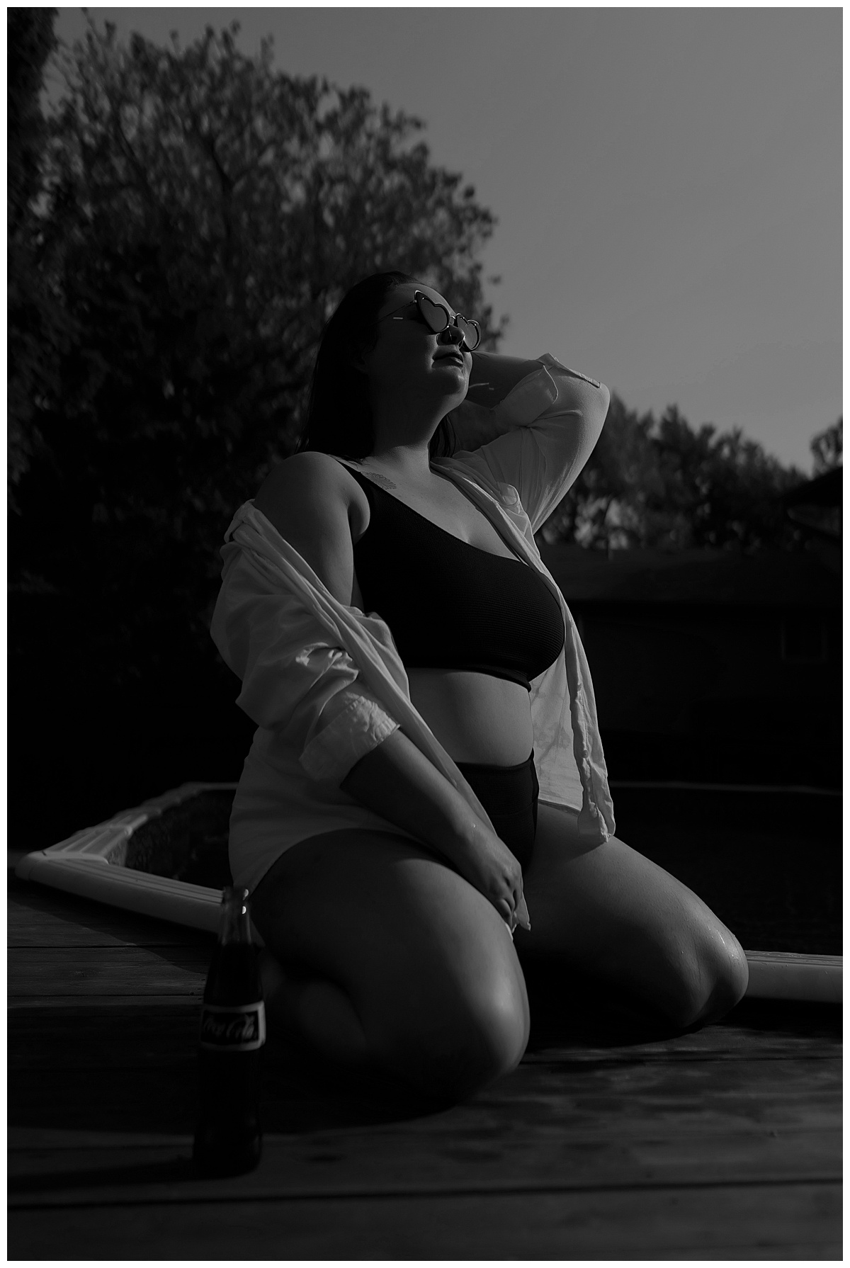Lady kneels on deck wearing a bathing suit for Emma Christine Photography