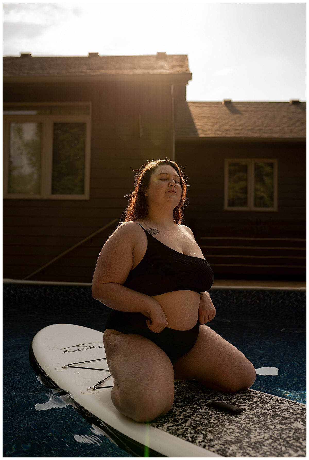 Lady kneel son paddle board wearing bathing suit for Emma Christine Photography