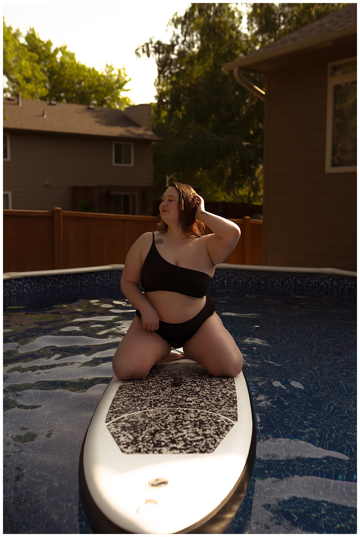 Person kneels on paddle board for Emma Christine Photography