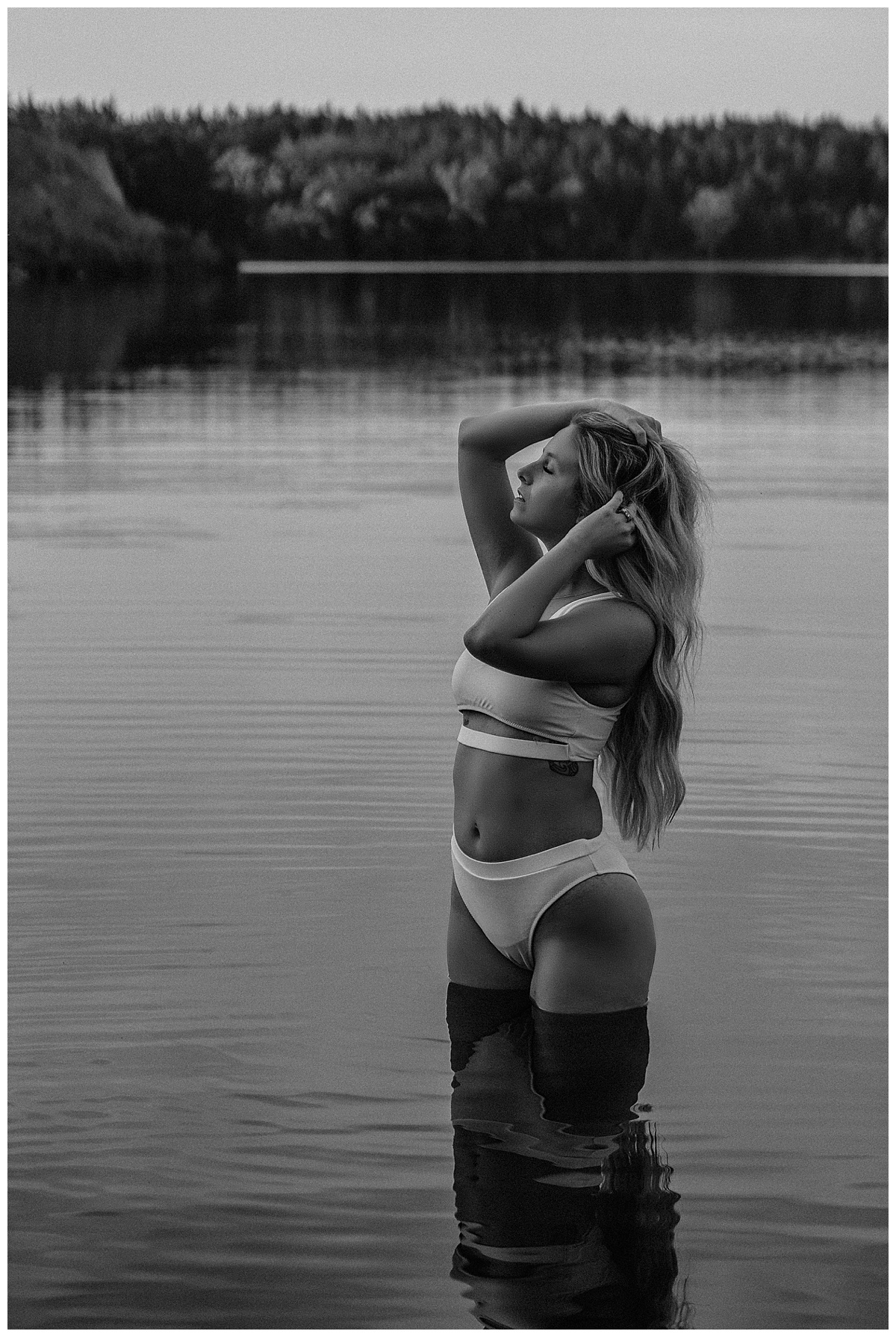 Woman stands in the water wearing white lingerie for Sioux Falls Boudoir Photographer