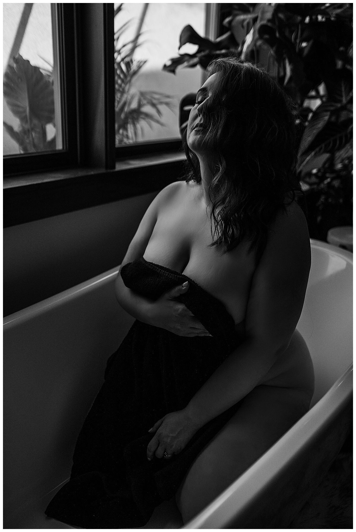 Girl sits in tub covered with sheet for Emma Christine Photography