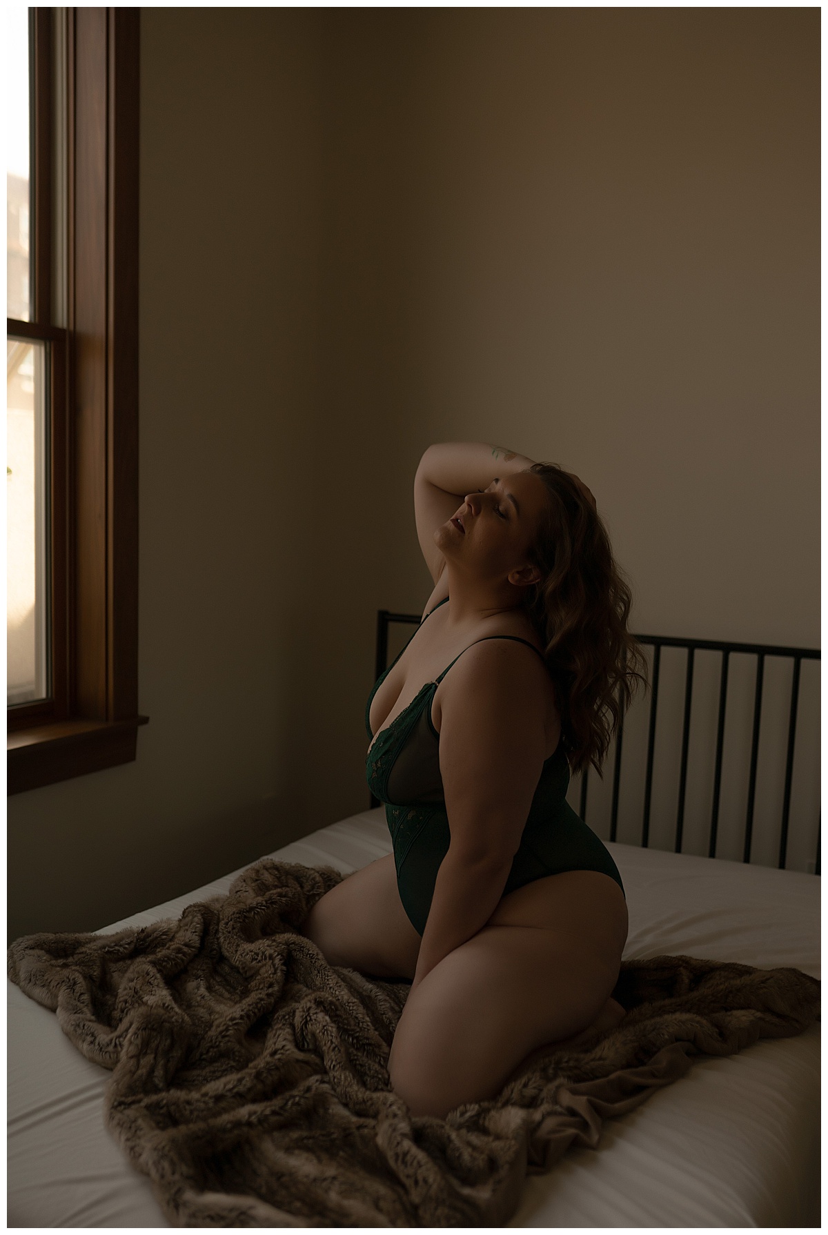Female sits on bed for Sioux Falls Boudoir Photographer
