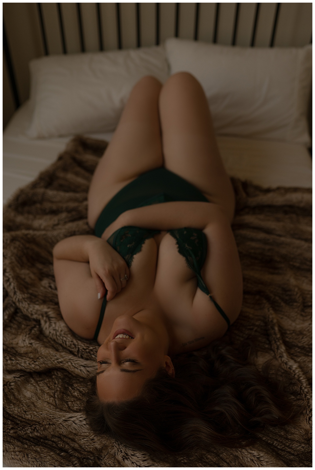 Woman lays on bed for Boudoir Experience