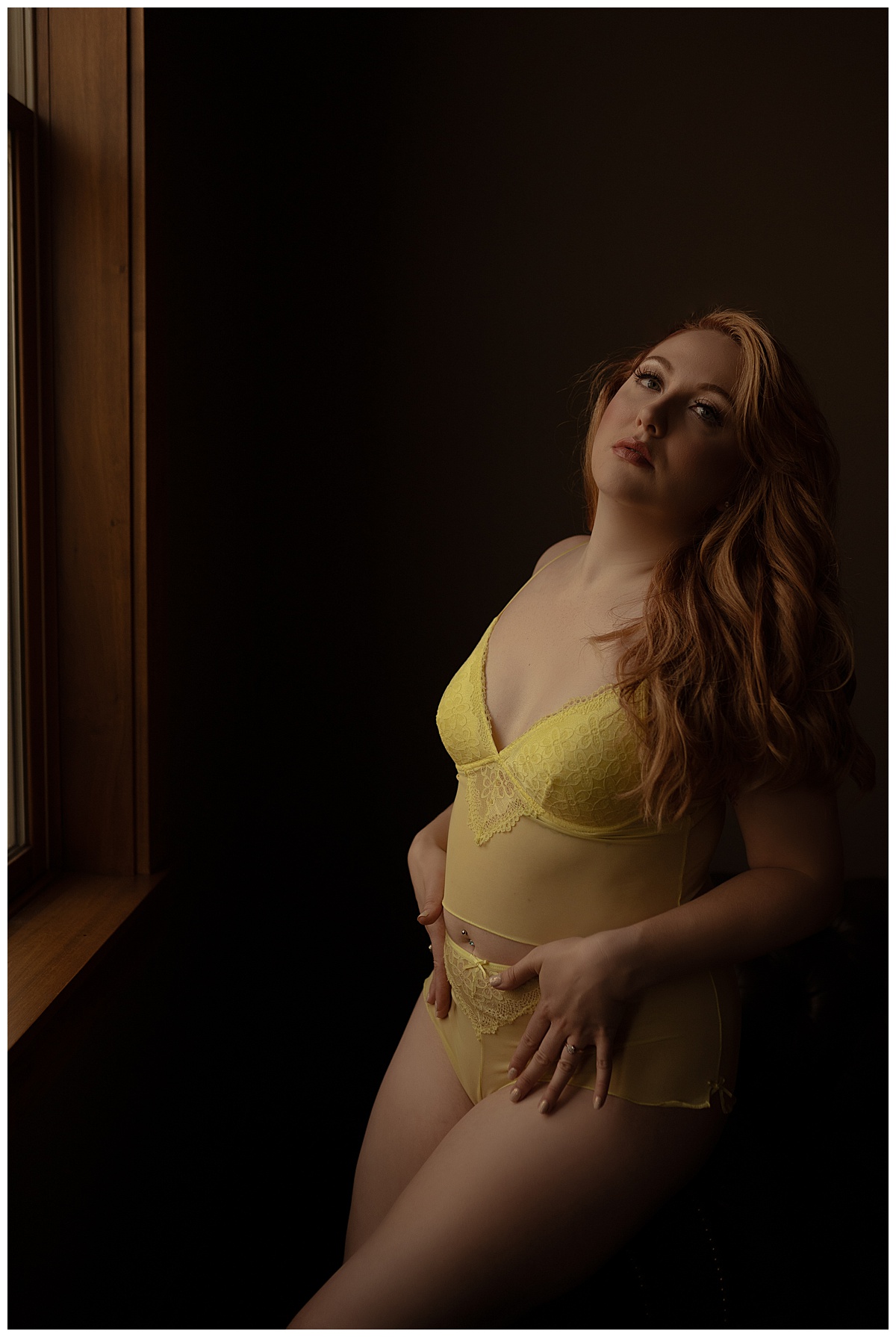 Girl holds hands against body in yellow lingerie for Sioux Falls Boudoir Photographer