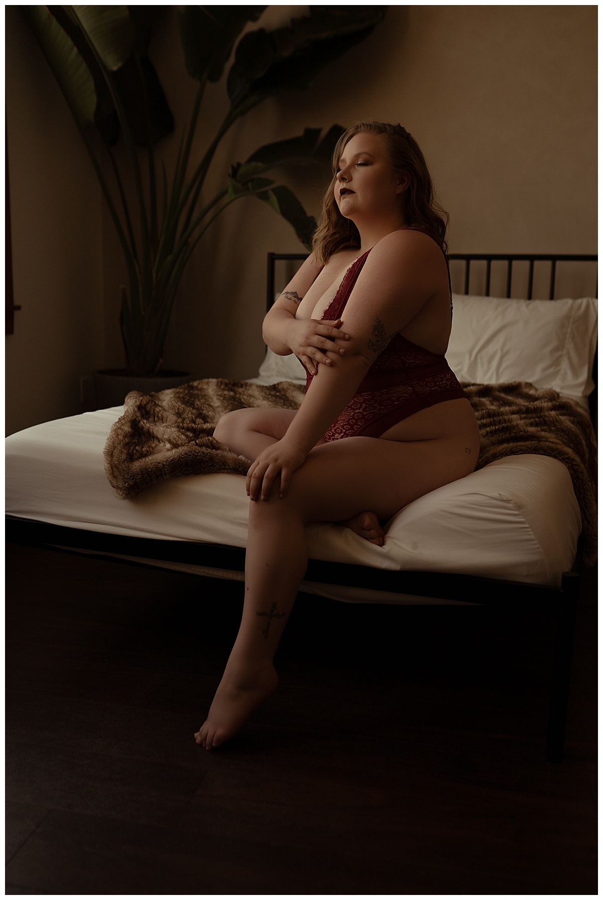 Adult sits on the edge of the bed for Emma Christine Photography