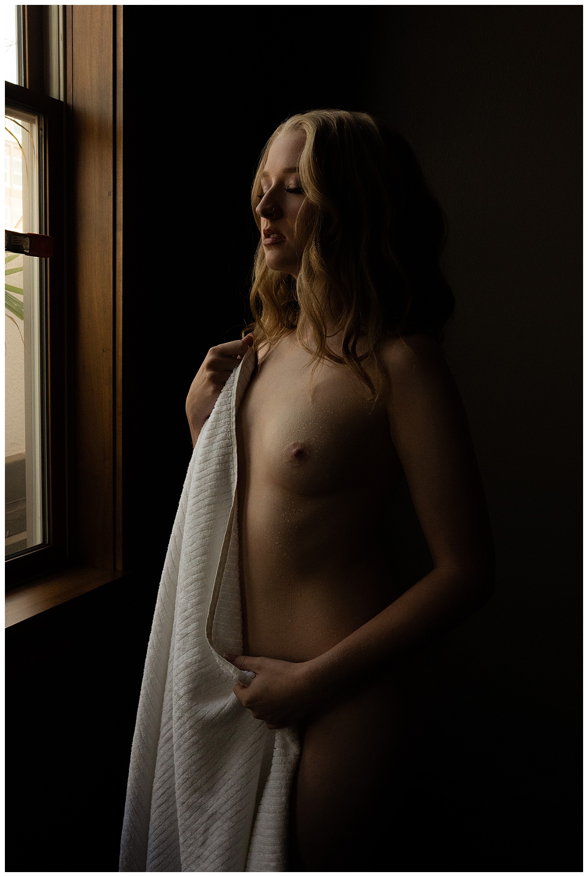 Adult covers body with towel for Sioux Falls Boudoir Photographer