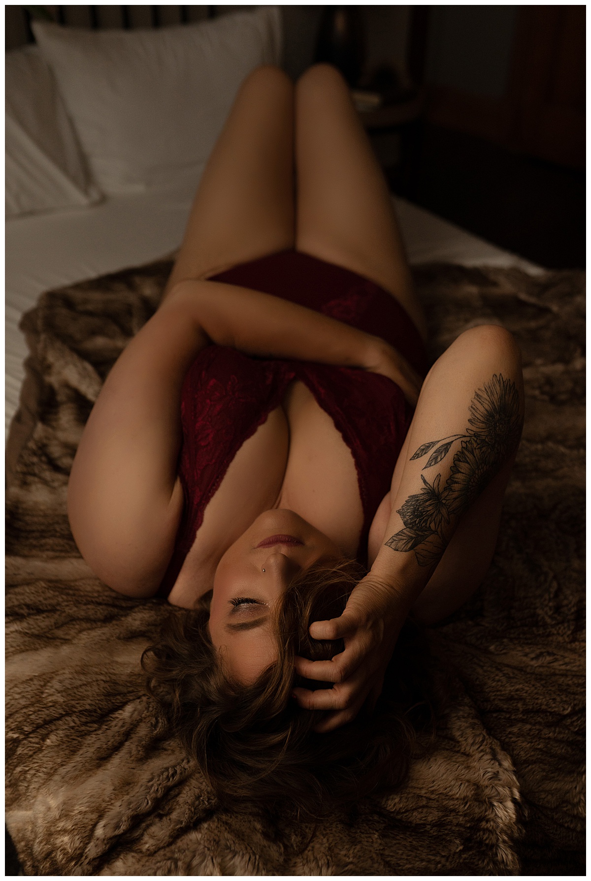 Female lays on bed for  Emma Christine Photography