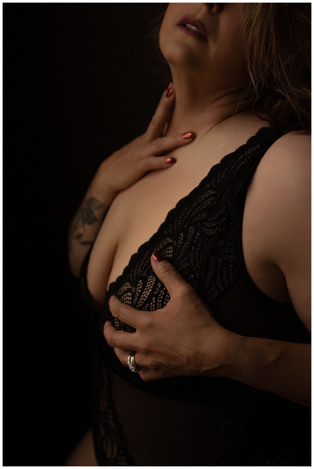 Adult covers chest wearing black lingerie for Emma Christine Photography