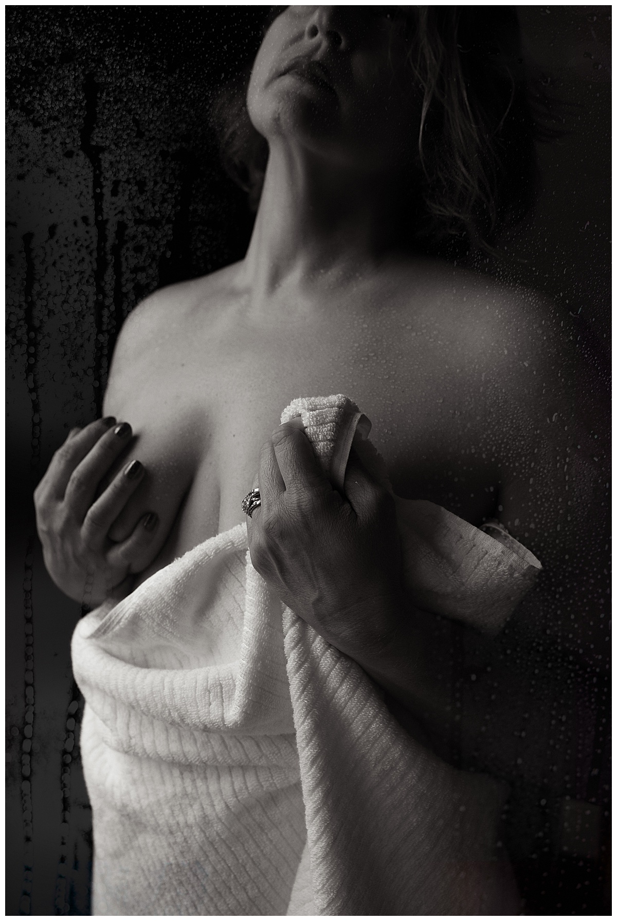 Woman brings towel to cover body for Sioux Falls Boudoir Photographer