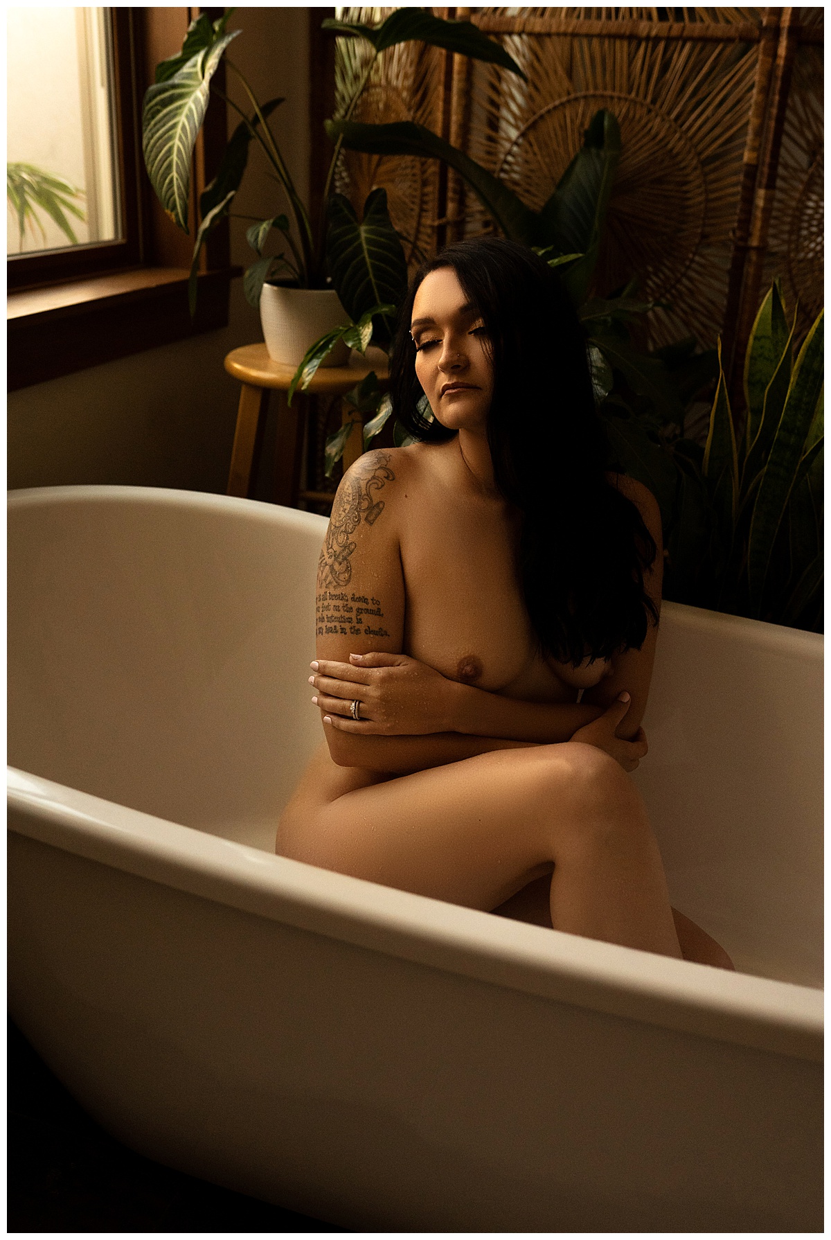 Girl covers body while sitting in a tub for Sioux Falls Boudoir Photographer