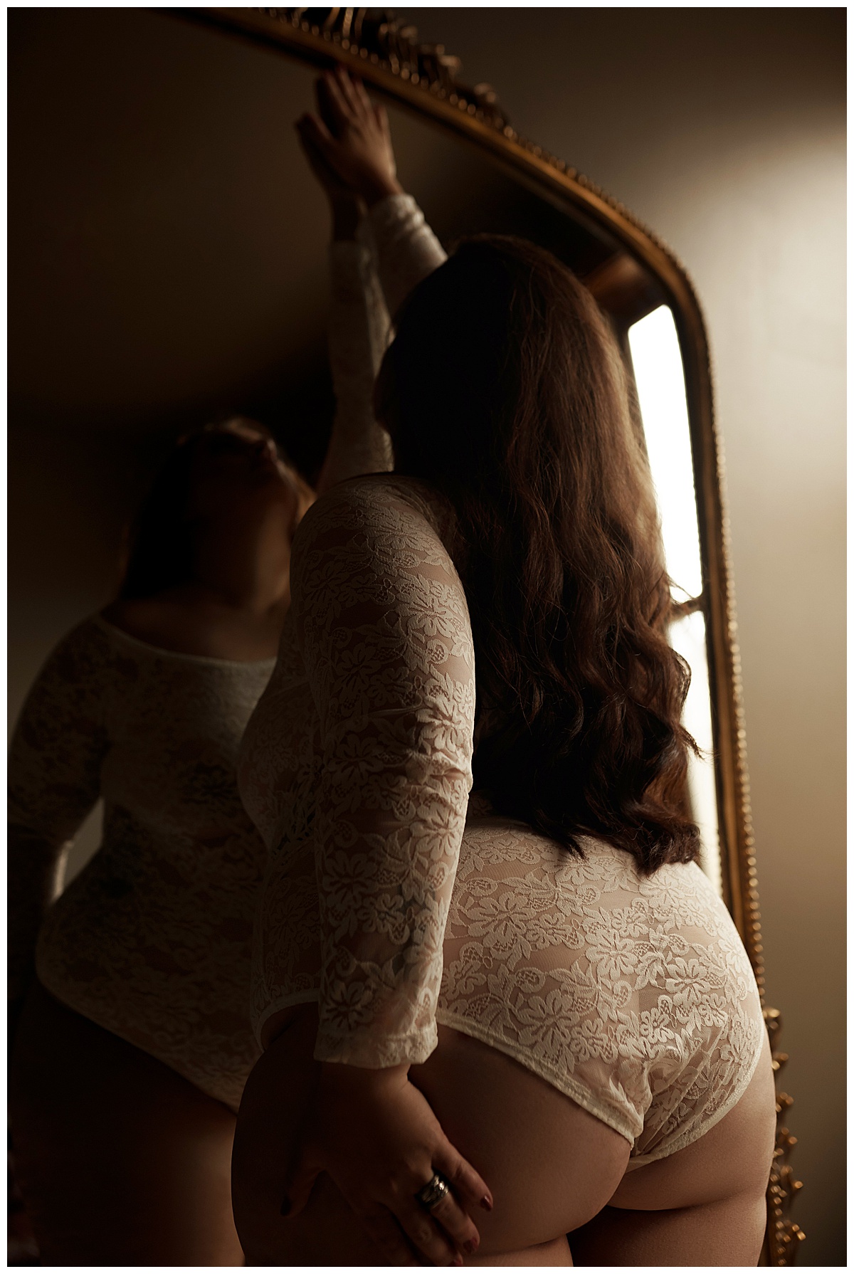 Person stands in front of the mirror wearing lingerie for Sioux Falls Boudoir Photographer