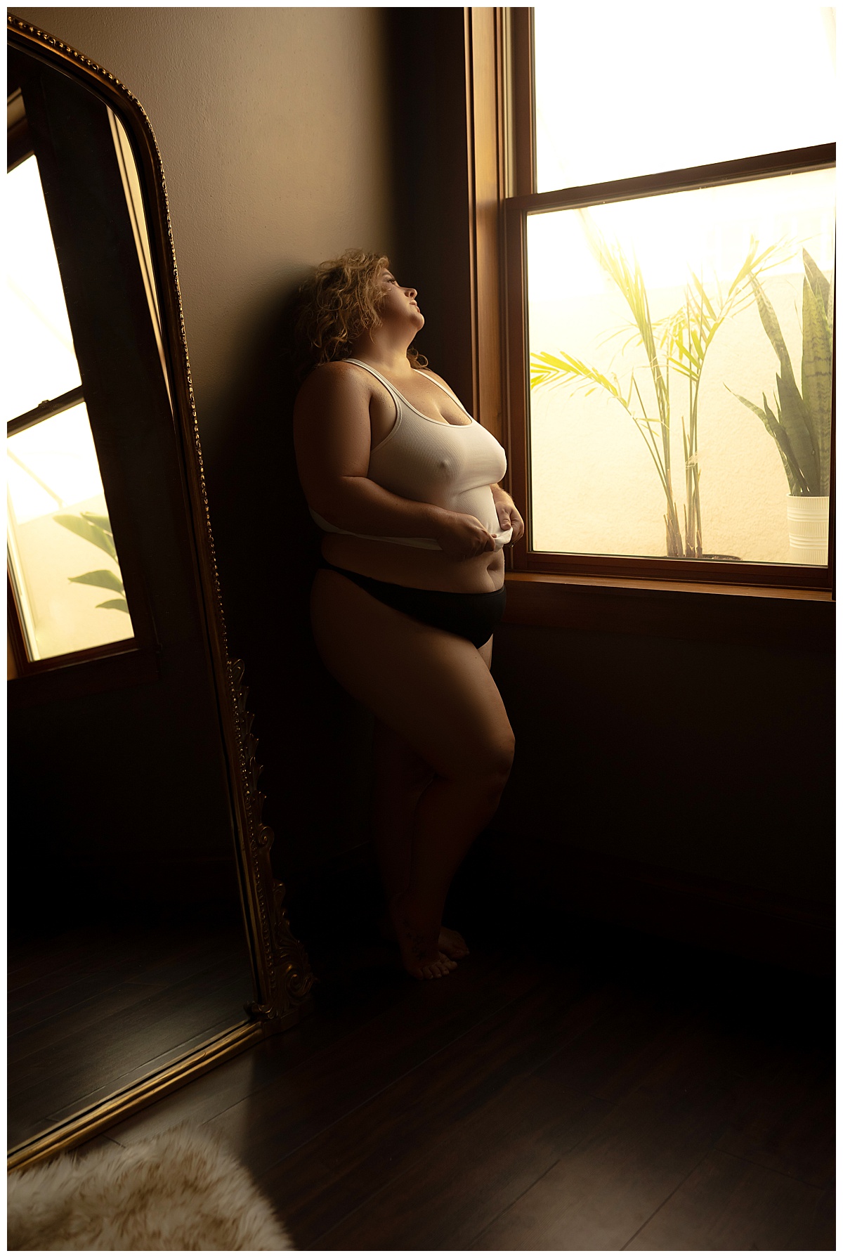 girls leans against the wall after wearing Lace Bodysuits during her boudoir photoshoot