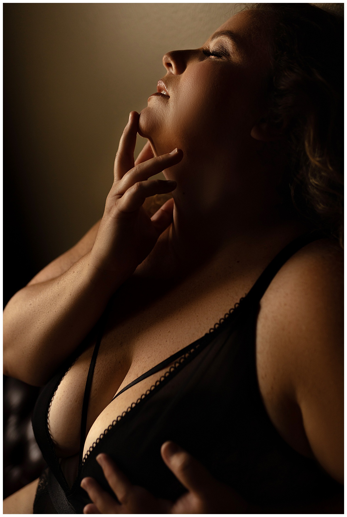 Adult holds her finger to her mouth for Sioux Falls Boudoir Photographer