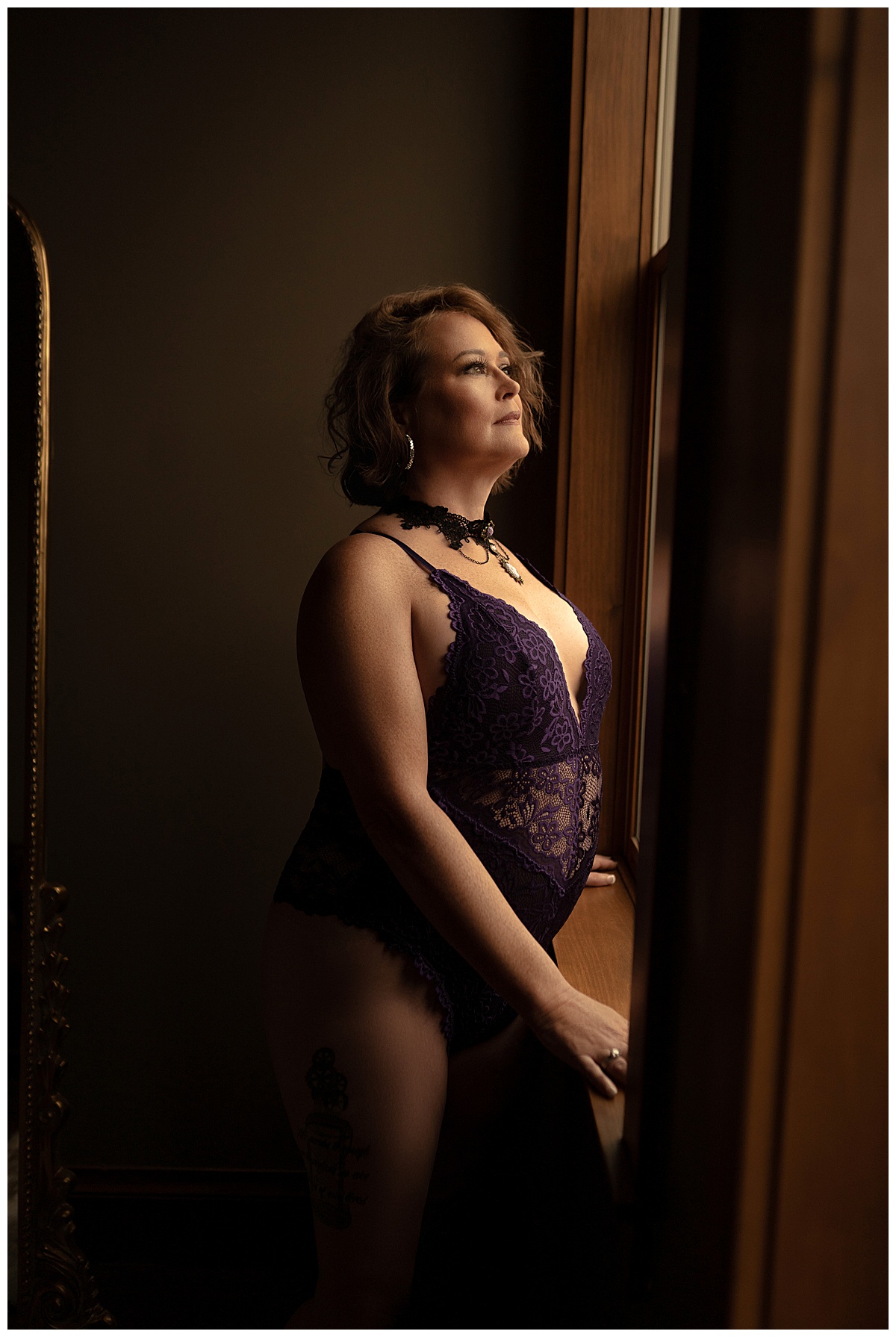 Adult stands in front of window for Sioux Falls Boudoir Photographer