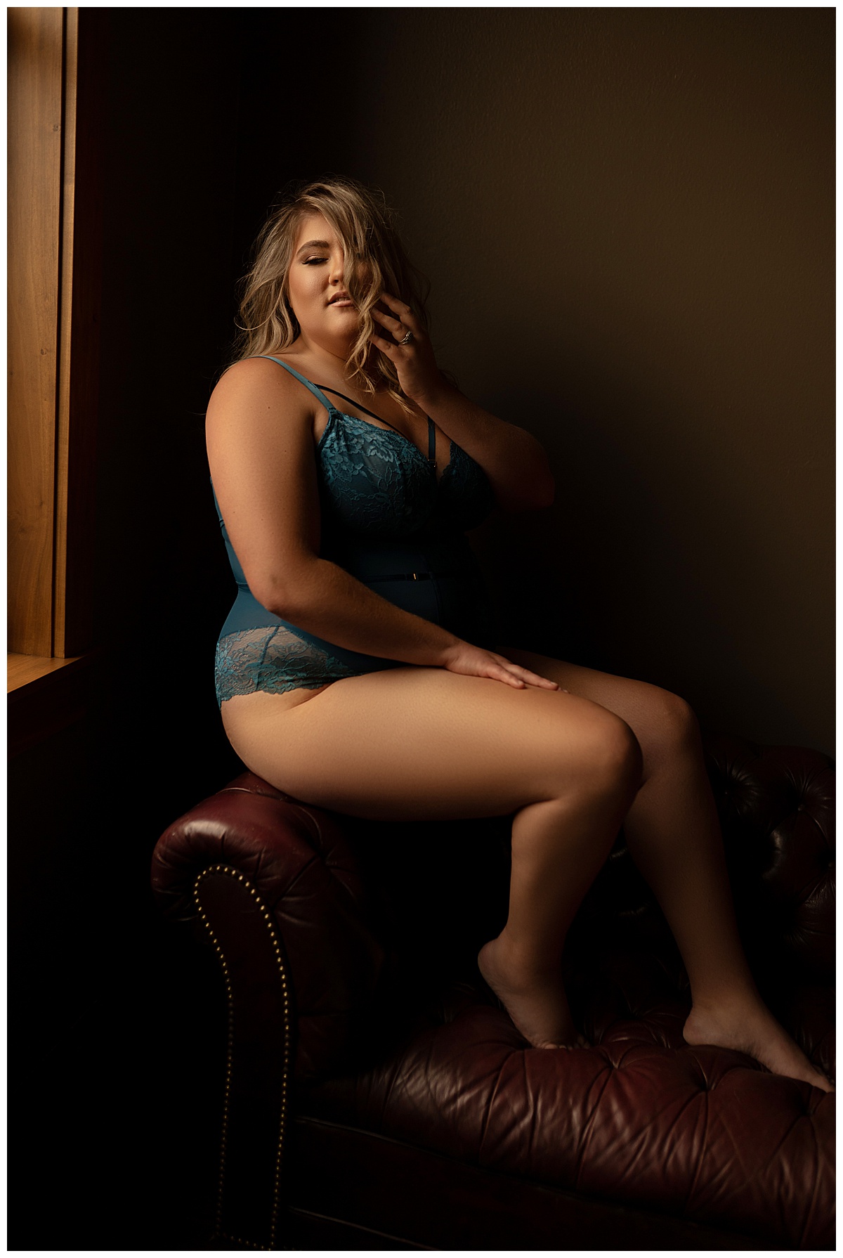 Girl sits on the arm of a chair wearing Blue Lace Lingerie 