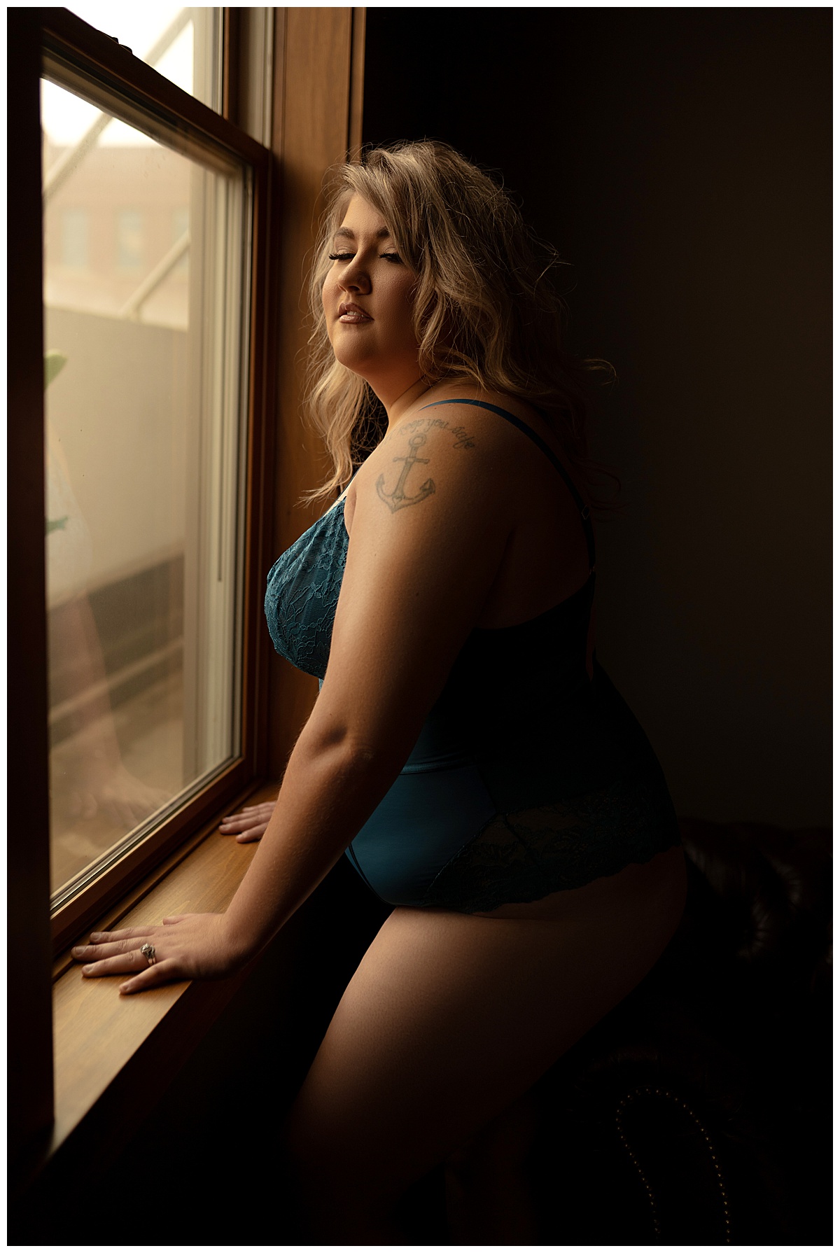 Person stands in front of a window wearing Blue Lace Lingerie 