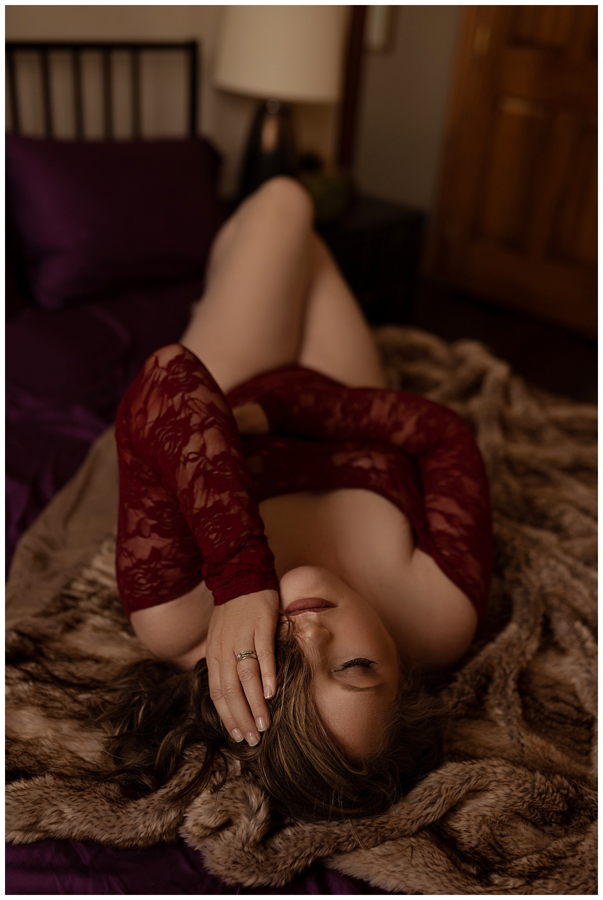 Person lays on the bed with her hands covering her face for Emma Christine Photography