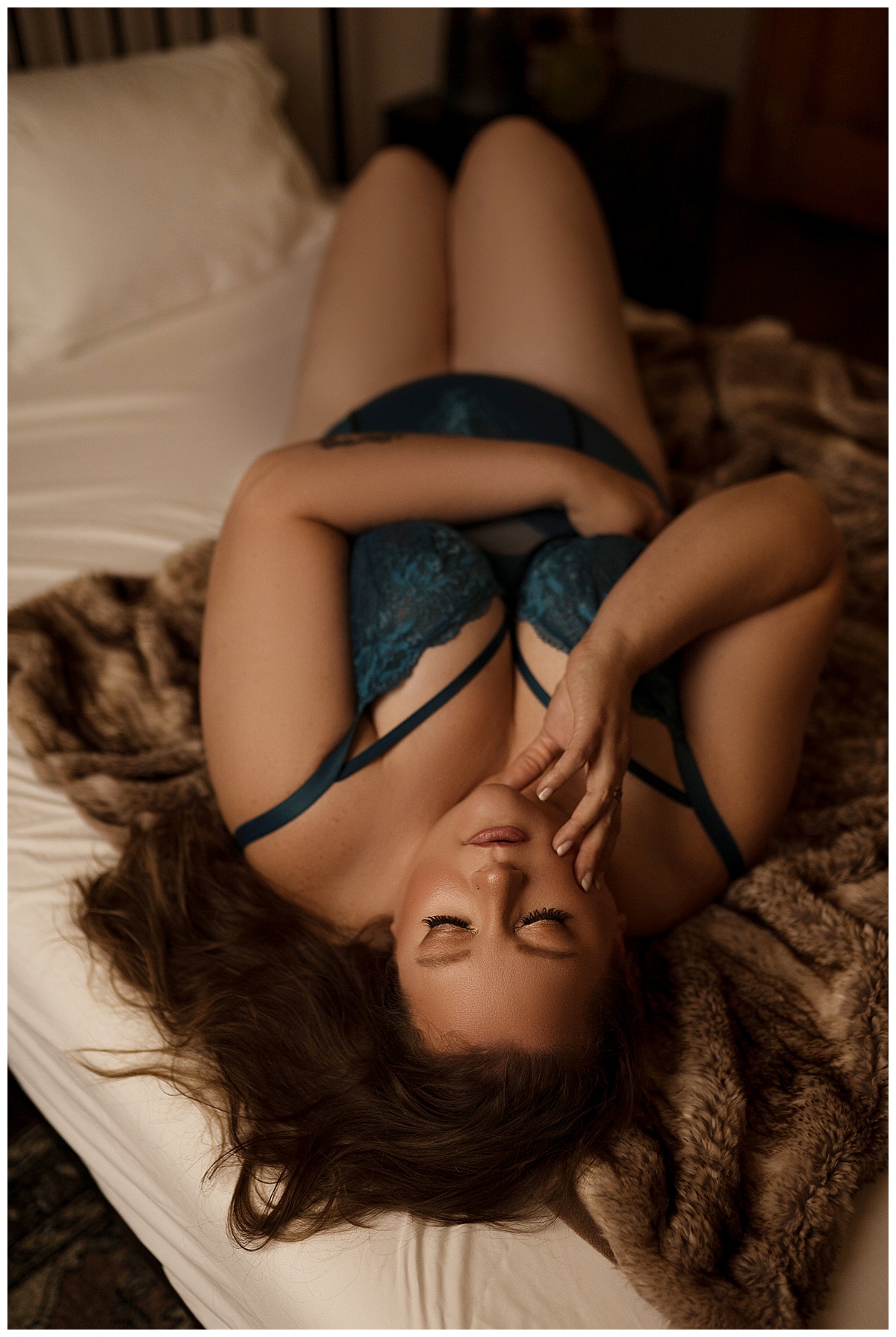 Person lays on the bed wearing blue lingerie for Sioux Falls Boudoir Photographer