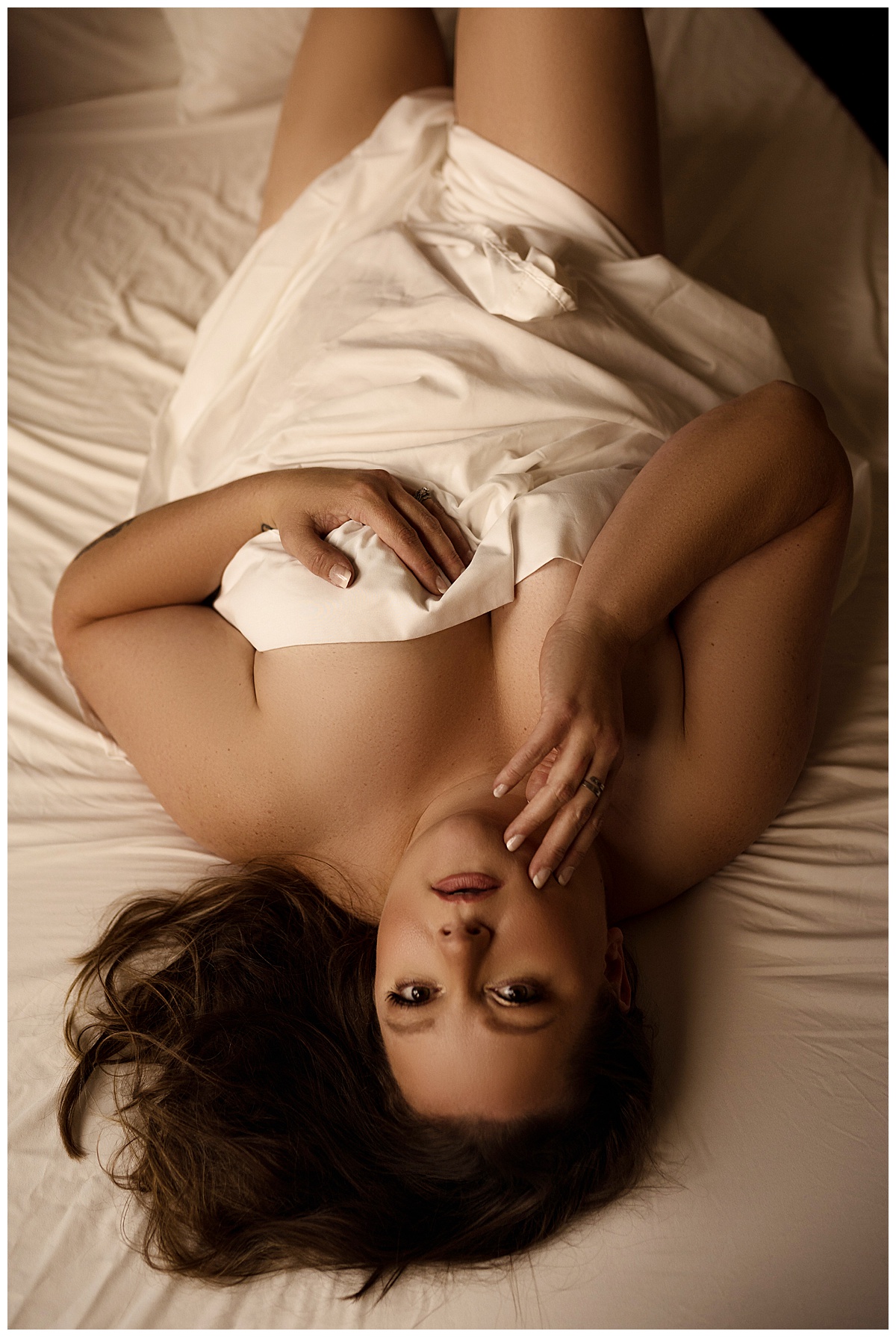Girl lays on the bed wrapped in a white sheet as a way to boost your self-confidence
