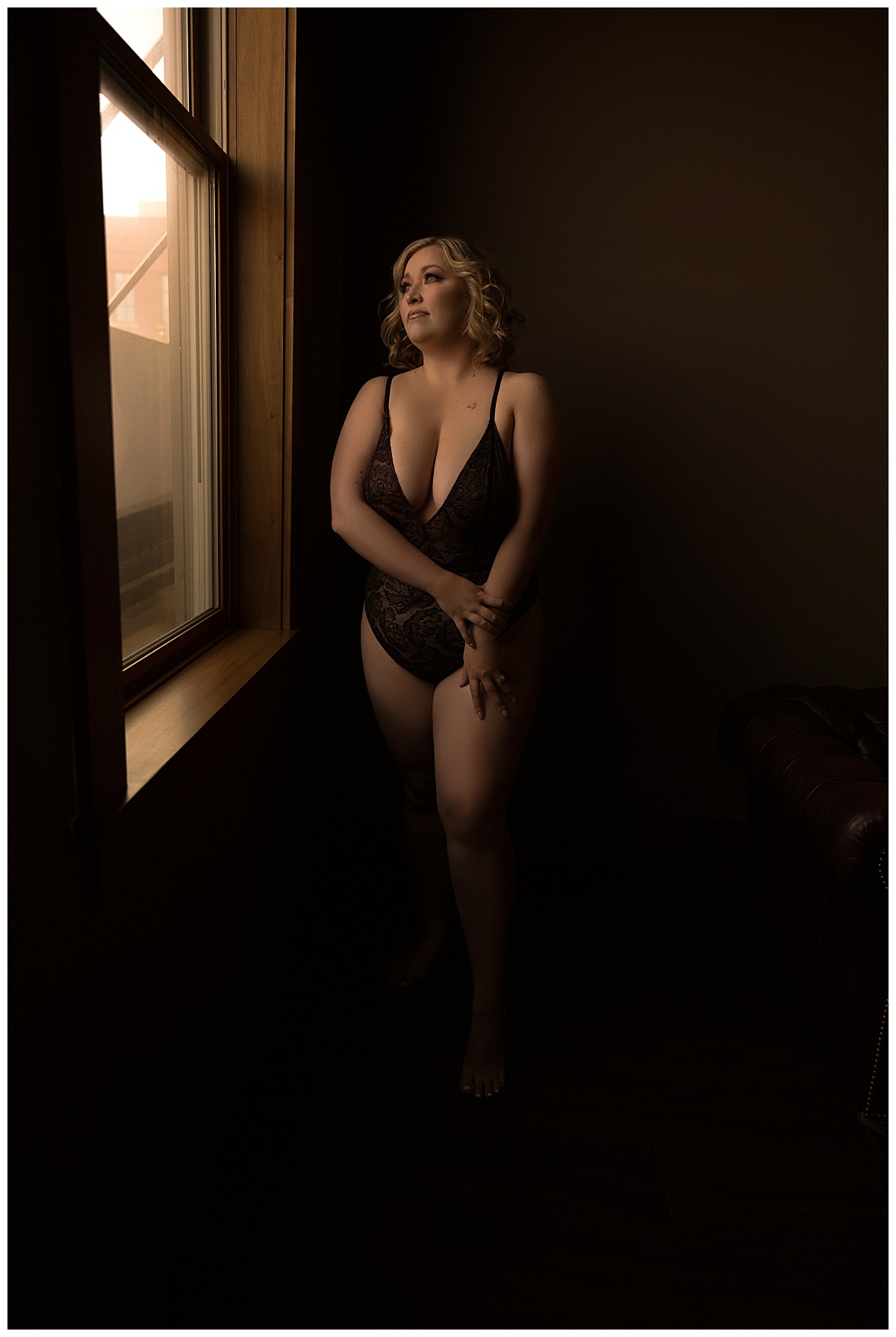 Person stands in front of a mirror wearing black lingerie for Sioux Falls Boudoir Photographer