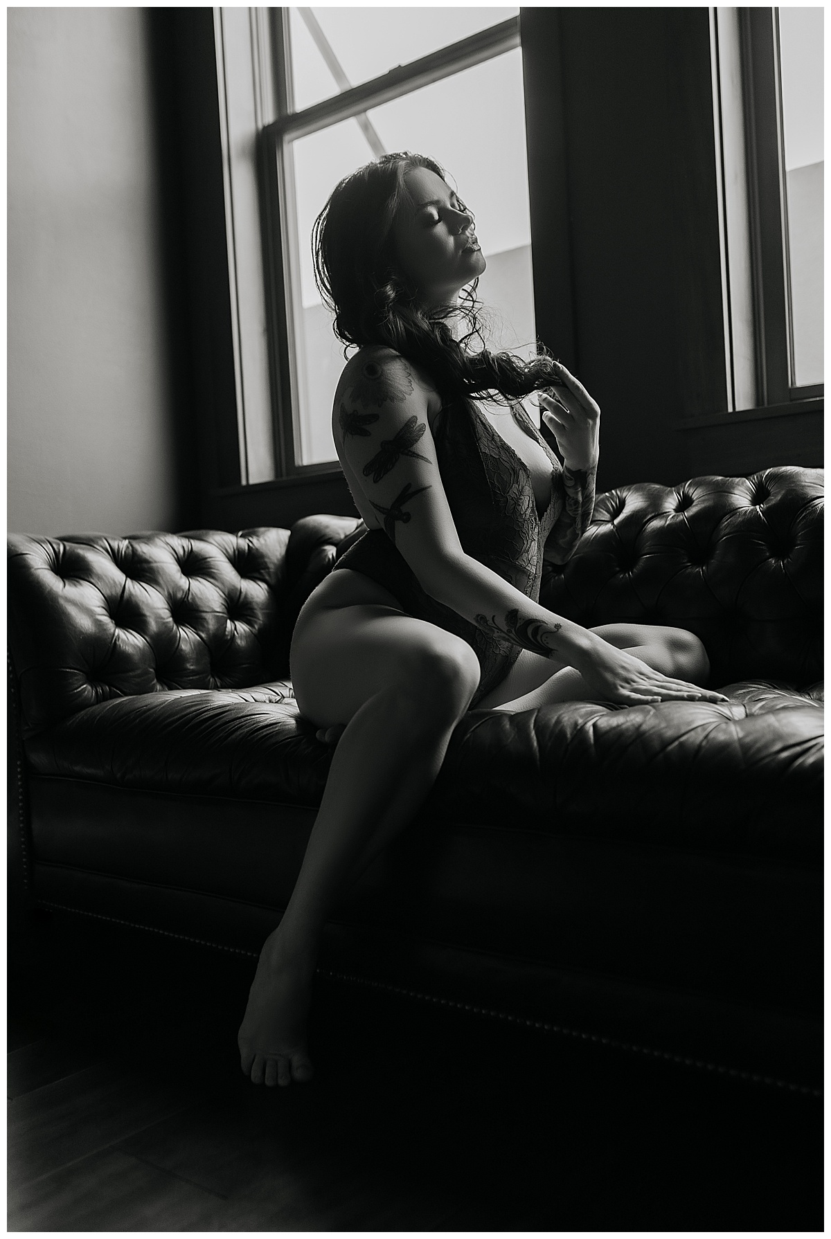 Person sits on the couch wearing lingerie for Emma Christine Photography