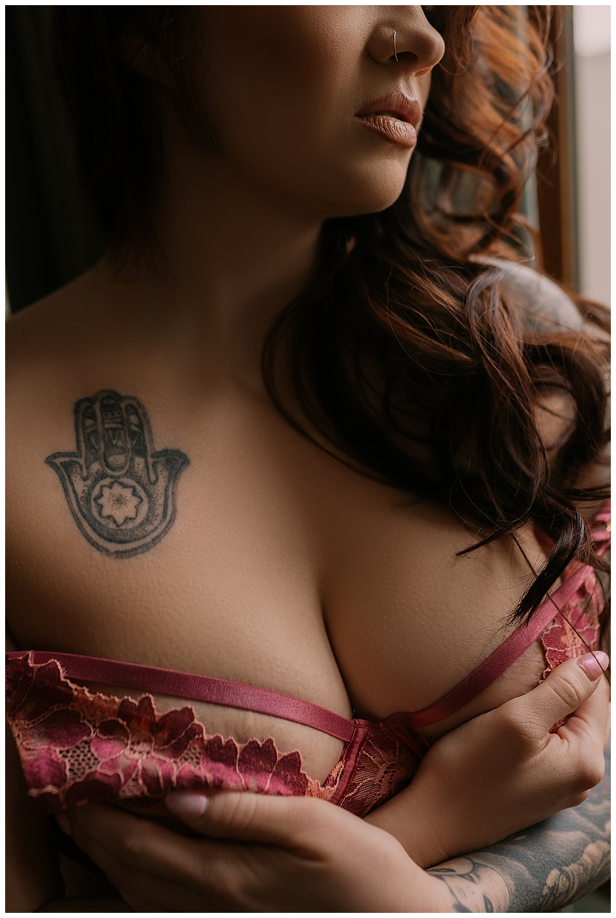 Person covers her chest wearing red lingerie for Sioux Falls Boudoir Photographer