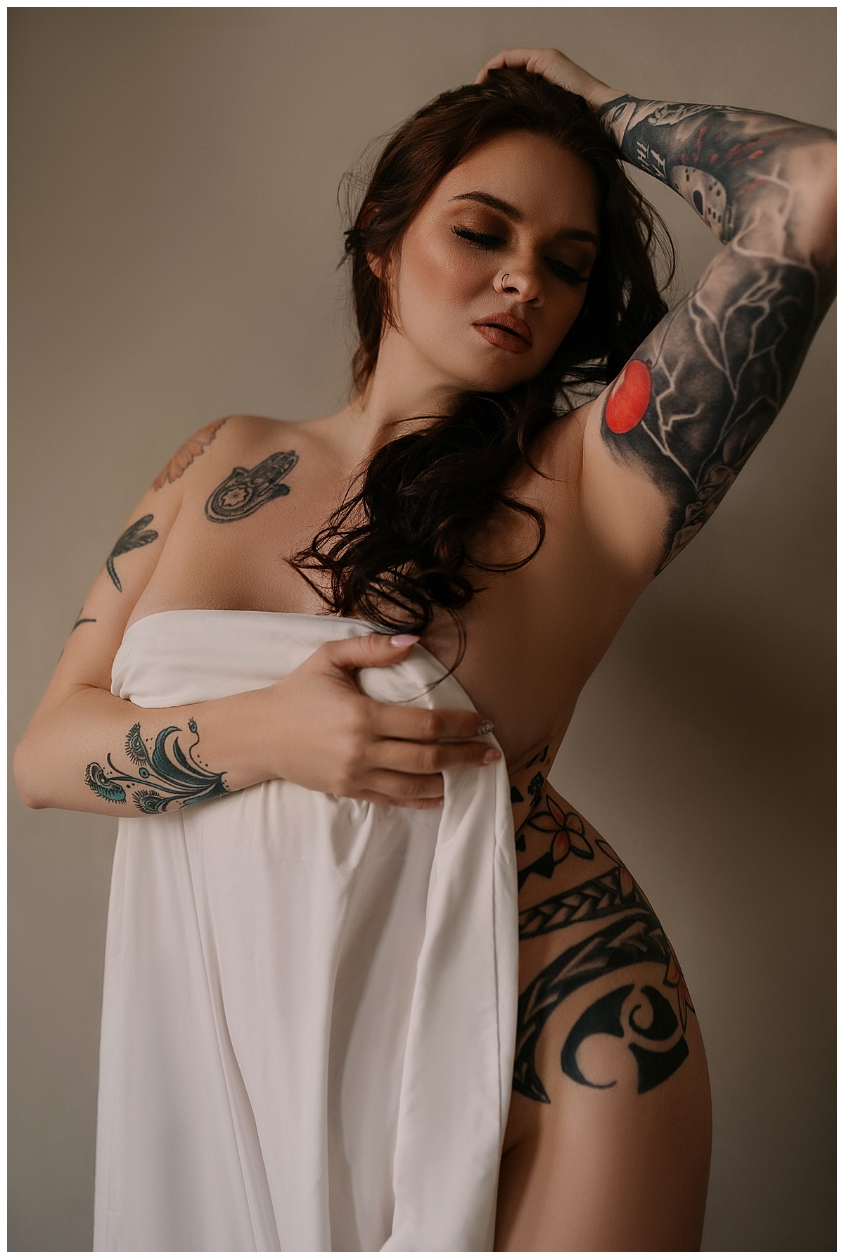 Adult cover her chest with a white sheet for Sioux Falls Boudoir Photographer