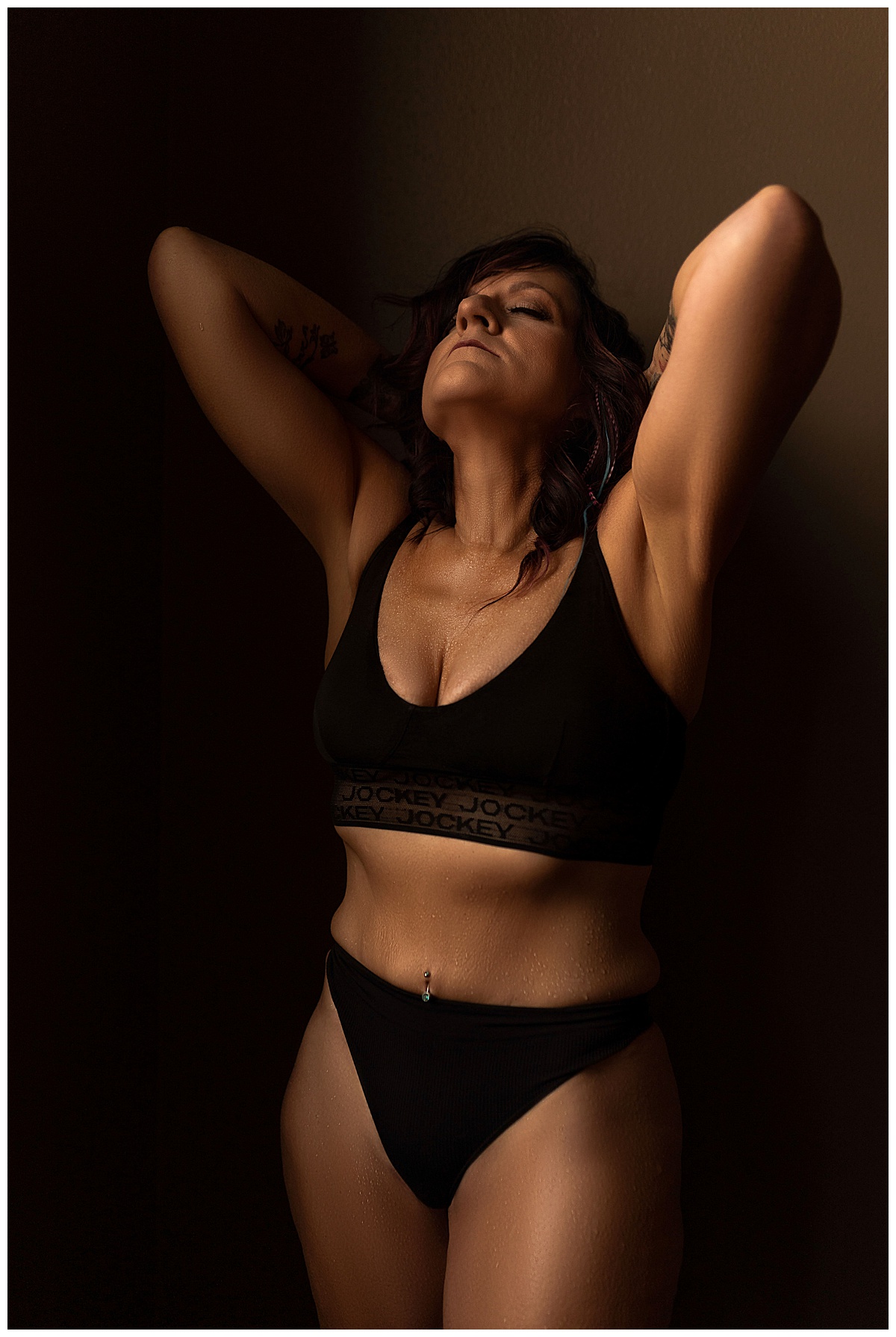 Woman holds hands above her head wearing lingerie for Emma Christine Photography