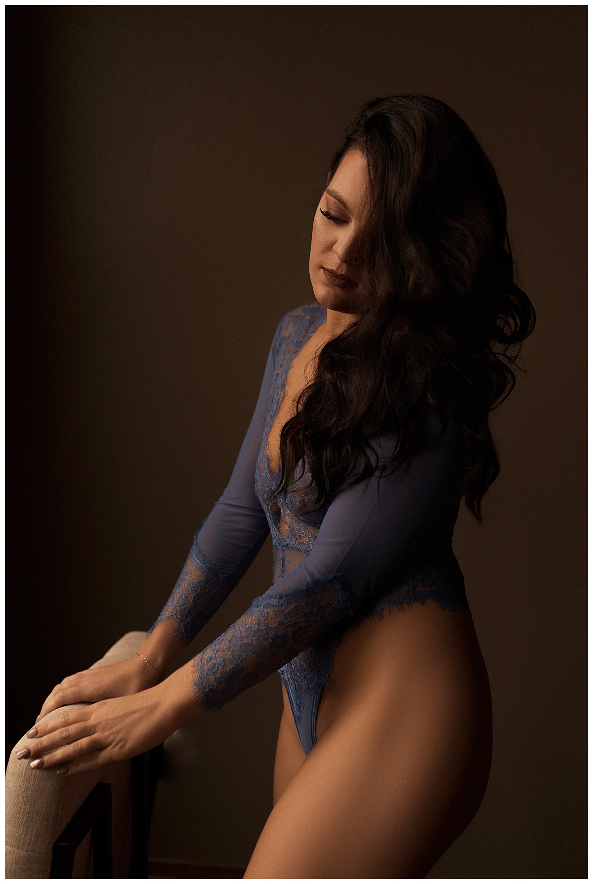 Girl stands behind a chair wearing blue lingerie for Sioux Falls Boudoir Photographer