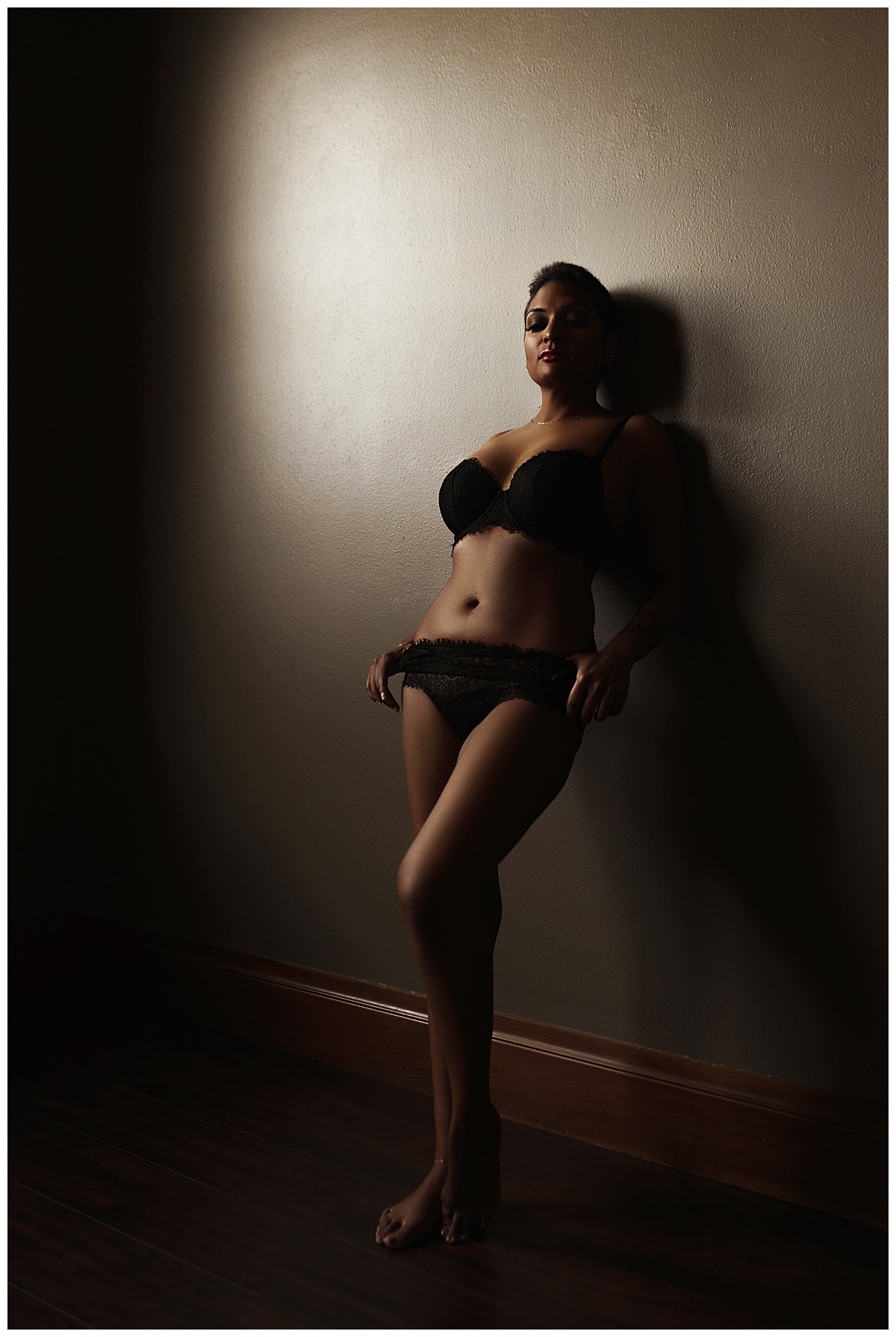 Person leans against the wall wearing lingerie for Emma Christine Photography