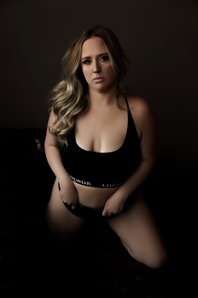 Adult kneels down wearing black lingerie for Sioux Falls Boudoir Photographer