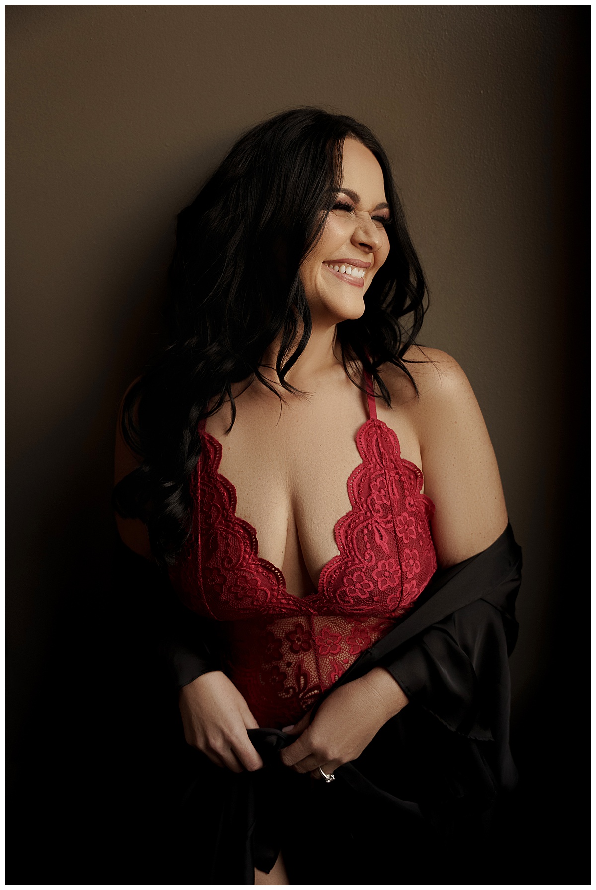 Adult smiles big wearing red lingerie for Sioux Falls Boudoir Photographer