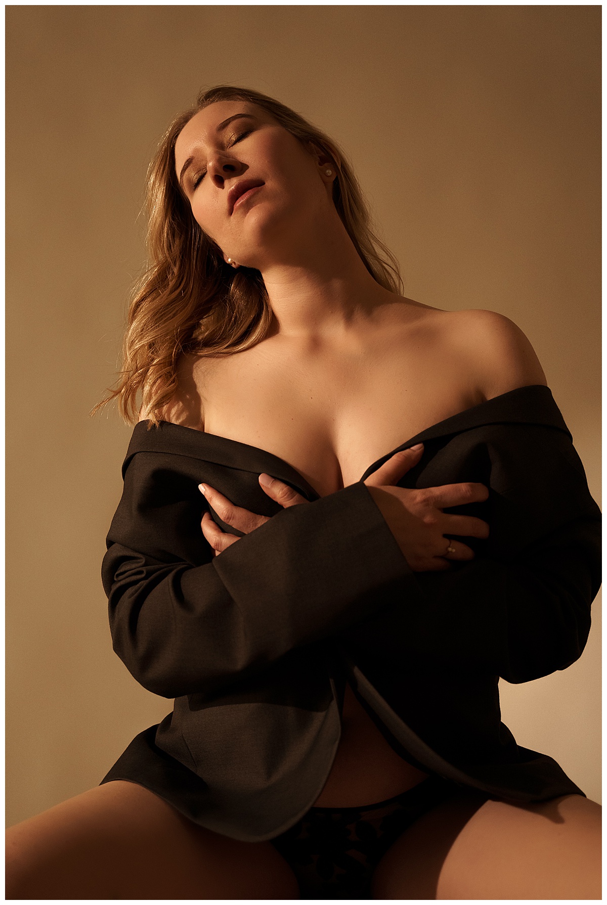 Girl covers her chest wearing a blazer for Sioux Falls Boudoir Photographer