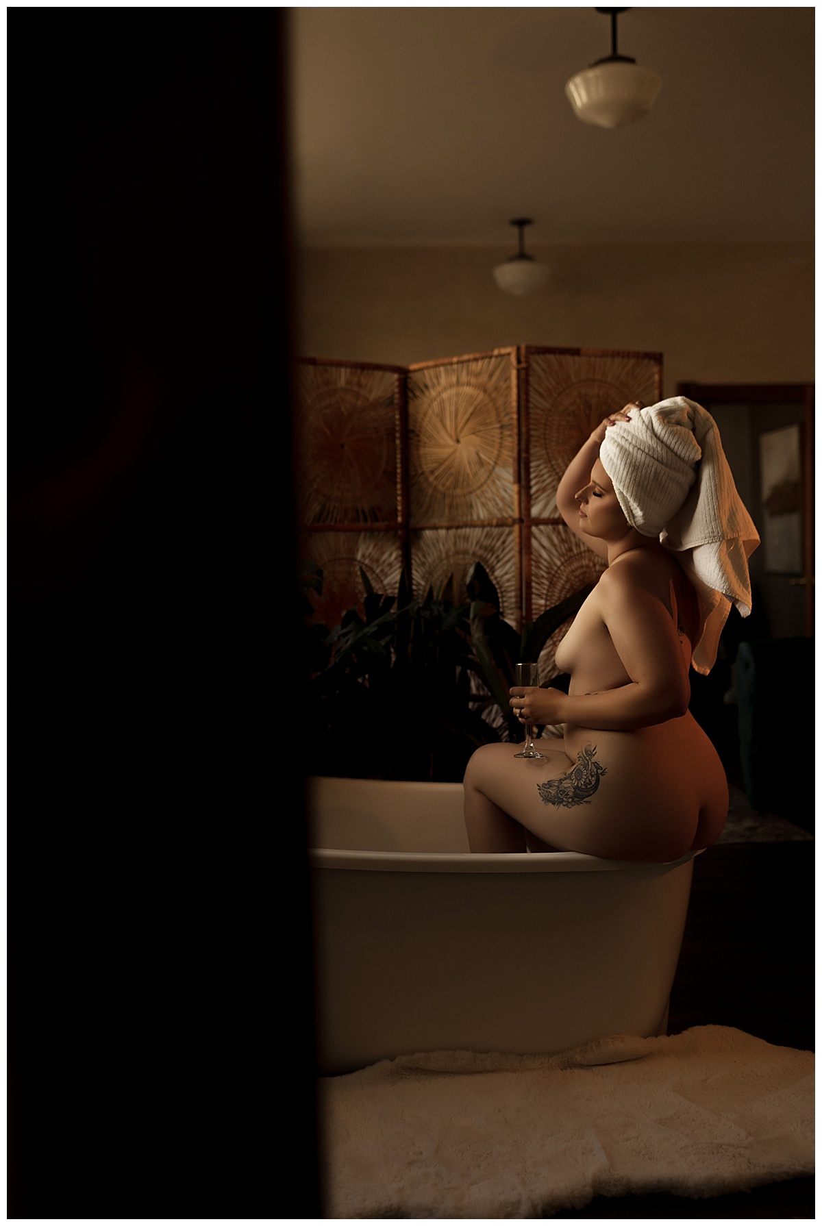 Woman sits on edge of bathtub for Emma Christine Photography