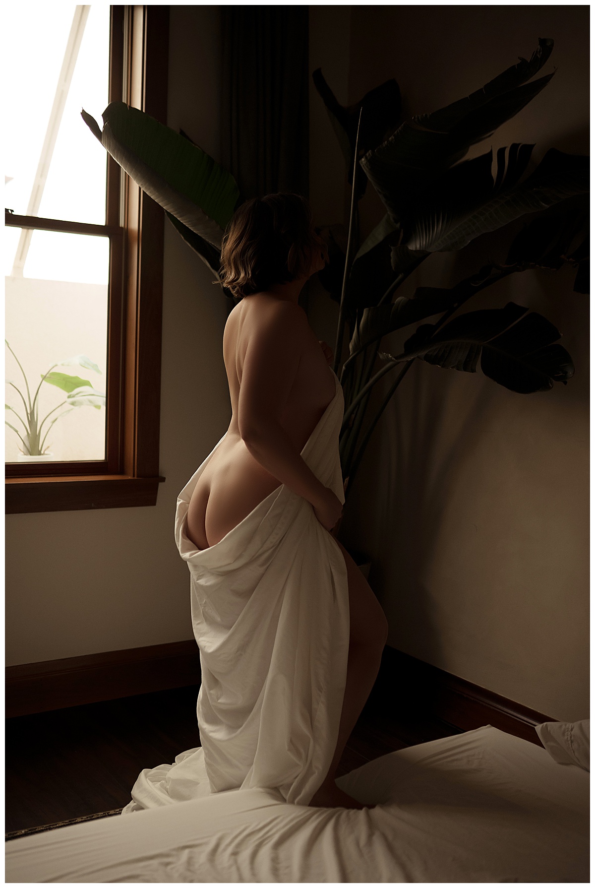 Adult wraps her body in a white sheet for Sioux Falls Boudoir Photographer