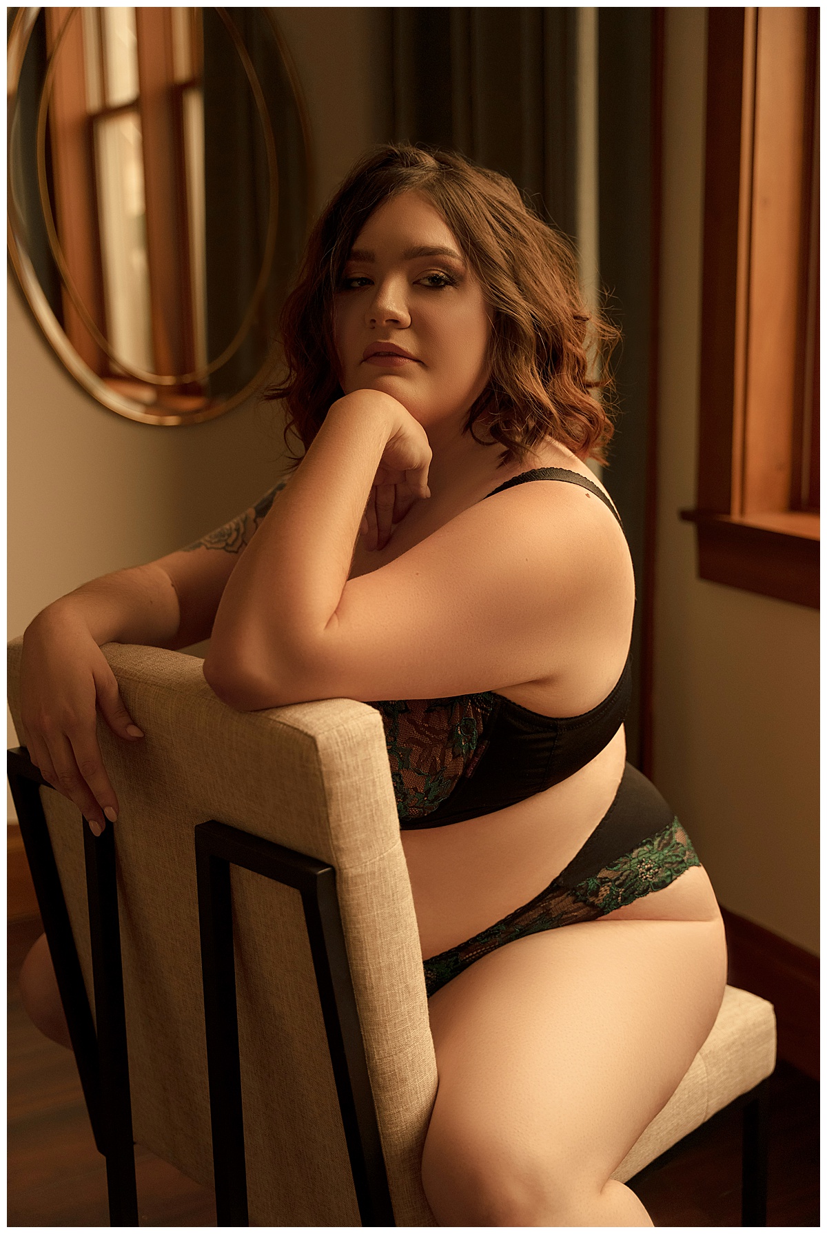 Woman sits on a chair wearing lingerie by Sioux Falls Boudoir Photographer