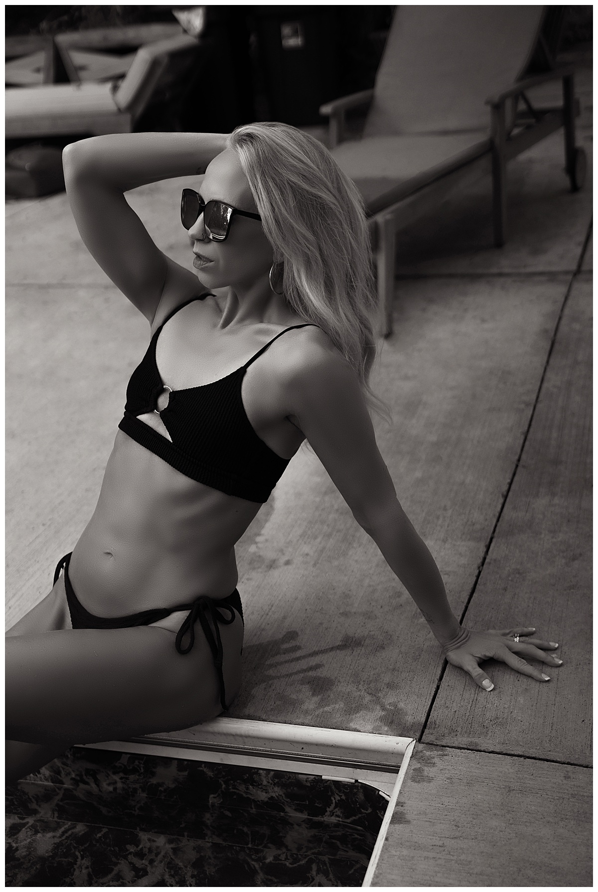 Person leans to the side wearing a bathing suit during her Poolside Boudoir Session