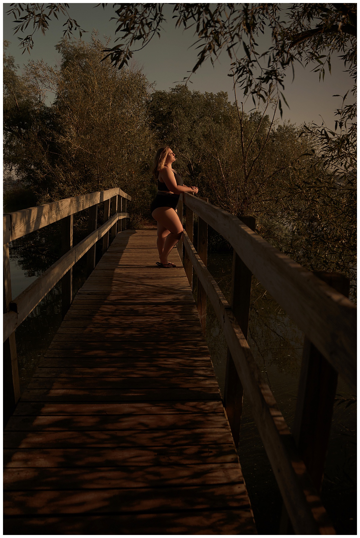 Female stands on the bridge during a Lakeside Boudoir session